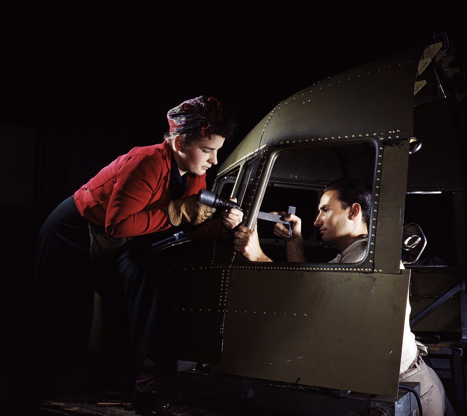 Riveting team working on the cockpit shell of a C-47 transport at the plant of North American Aviation 